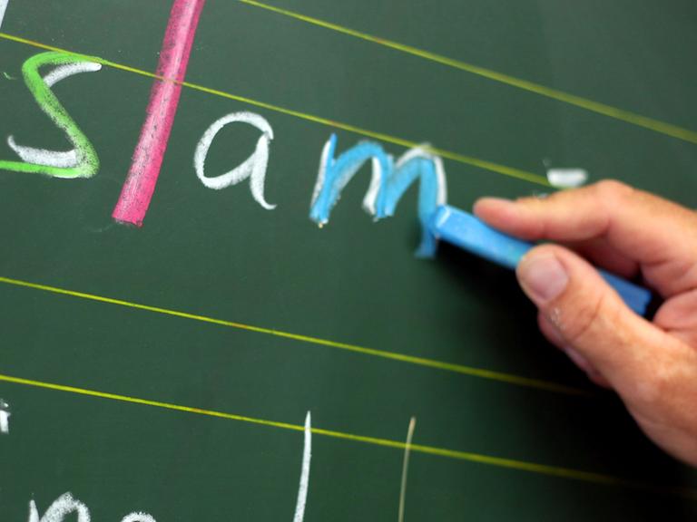 Der Religionslehrer Ridwan Bauknecht schreibt am Montag (27.08.2012) in Bonn an der Robert-Koch-Schule während des islamischen Religionsunterrichts an die Tafel.