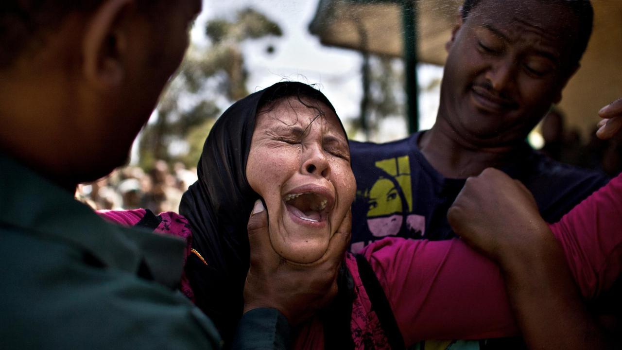 Eine Frau wird von zwei Männern festgehalten und weint - Bilder einer Teufelsaustreibung im Januar 2014 in Addis Abeba, Äthiopien. Eine Frau wird von zwei Männern festgehalten und weint - Bilder einer Teufelsaustreibung im Januar 2014 in Addis Abeba, Äthiopien.