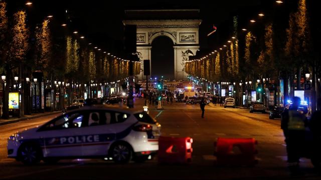 Polizisten blockieren die Einfahrt zum Pariser Boulevard Champs-Élysées. Dort sind Polizisten angegriffen worden.