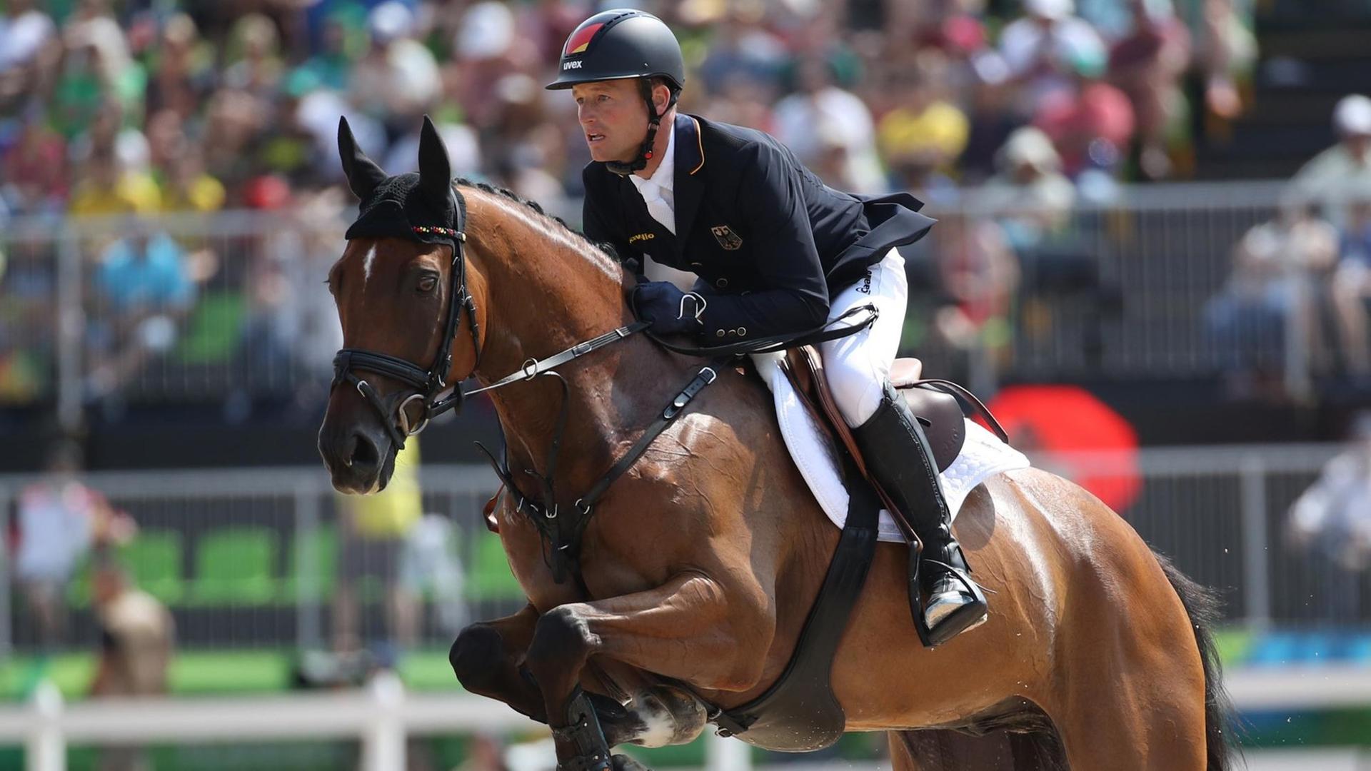 Der deutsche Vielseitigkeitsreiter Michael Jung auf seinem Pferd Sam beim Sprung. Der deutsche Vielseitigkeitsreiter Michael Jung auf seinem Pferd Sam beim Sprung.