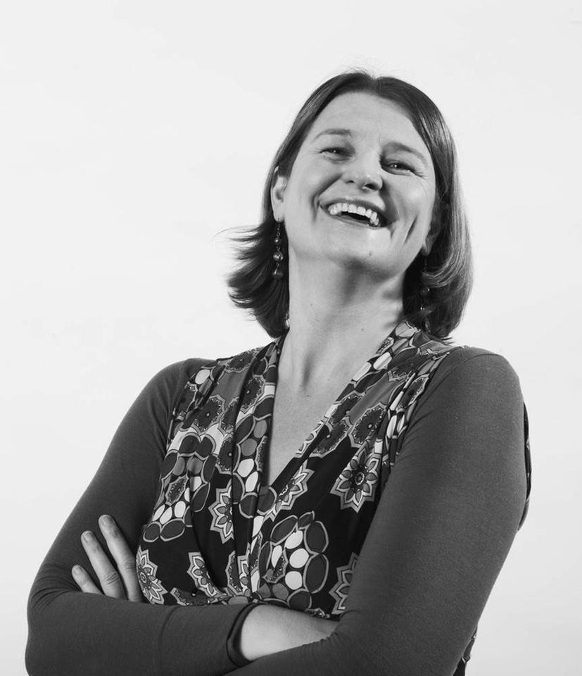 Prof. Nathalie Singer. Frau Singer steht lachend mit verschränkten Armen dem Fotografen zugewandt. Das Foto ist in schwarz-weiß Prof. Nathalie Singer. Frau Singer steht lachend mit verschränkten Armen dem Fotografen zugewandt. Das Foto ist in schwarz-weiß
