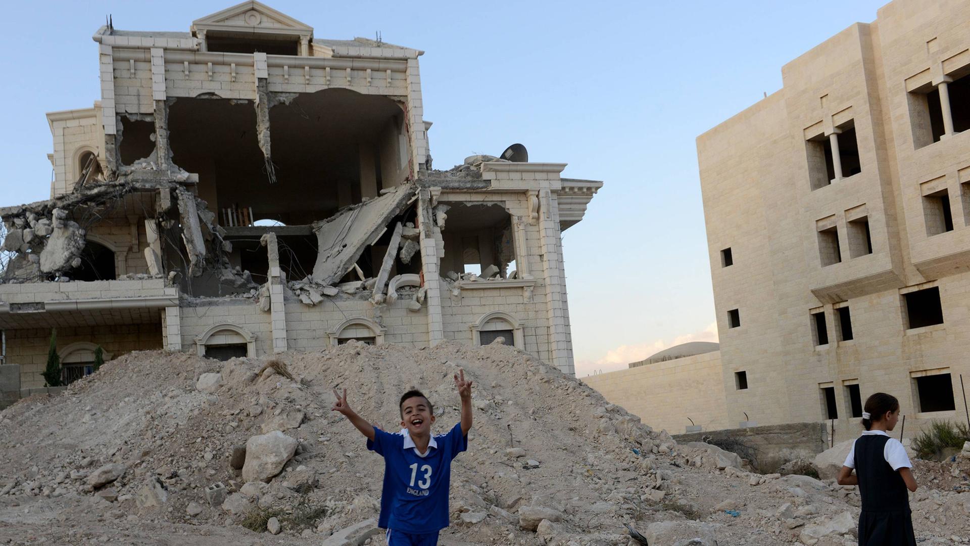 Ein palästinischer Junge zeigt das Victory-Zeichen vor einem zertrümmerten Haus in Abu Dis, Westbank. Ein palästinischer Junge zeigt das Victory-Zeichen vor einem zertrümmerten Haus in Abu Dis, Westbank.