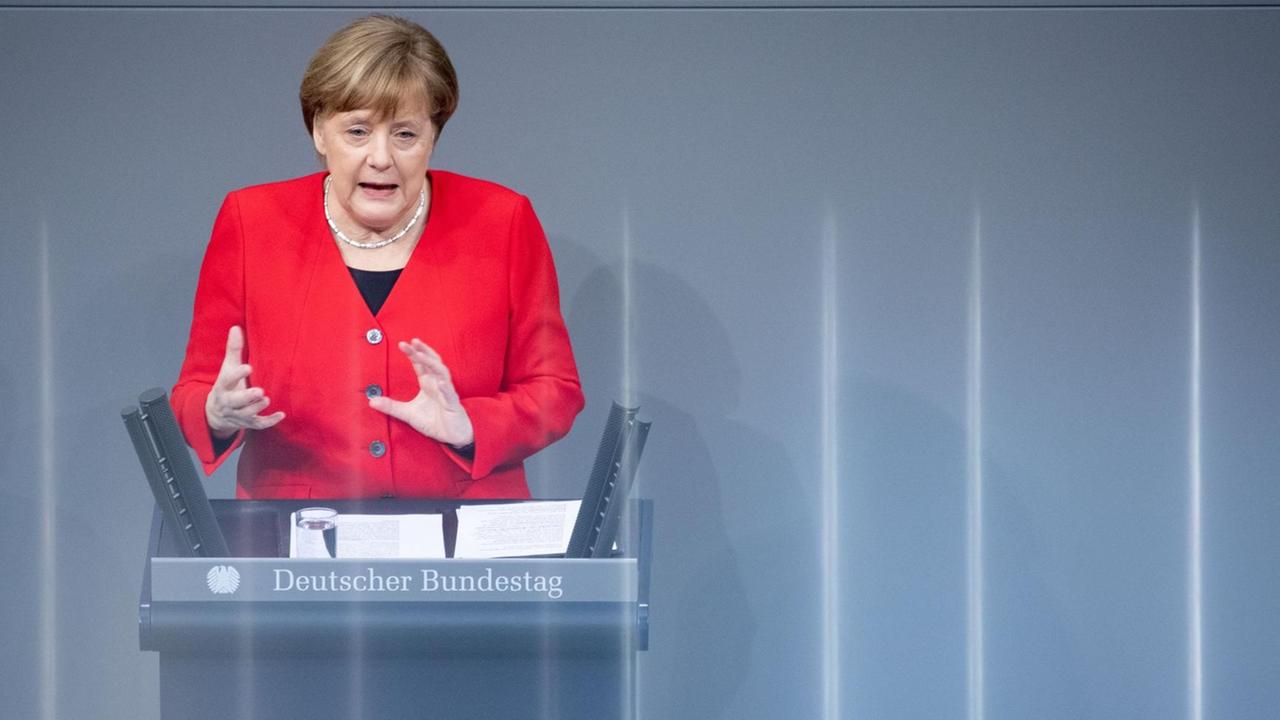 Angela Merkel redet im roten Blazer im Deutschen Bundestag Angela Merkel redet im roten Blazer im Deutschen Bundestag