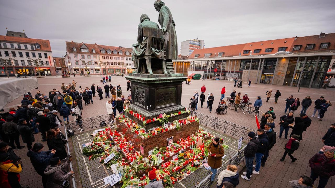 Menschen stehen um das Brüder-Grimm-Nationaldenkmal an dem zum Gedenken an die Anschläge Blumen niedergelegt wurden. Menschen stehen um das Brüder-Grimm-Nationaldenkmal an dem zum Gedenken an die Anschläge Blumen niedergelegt wurden.