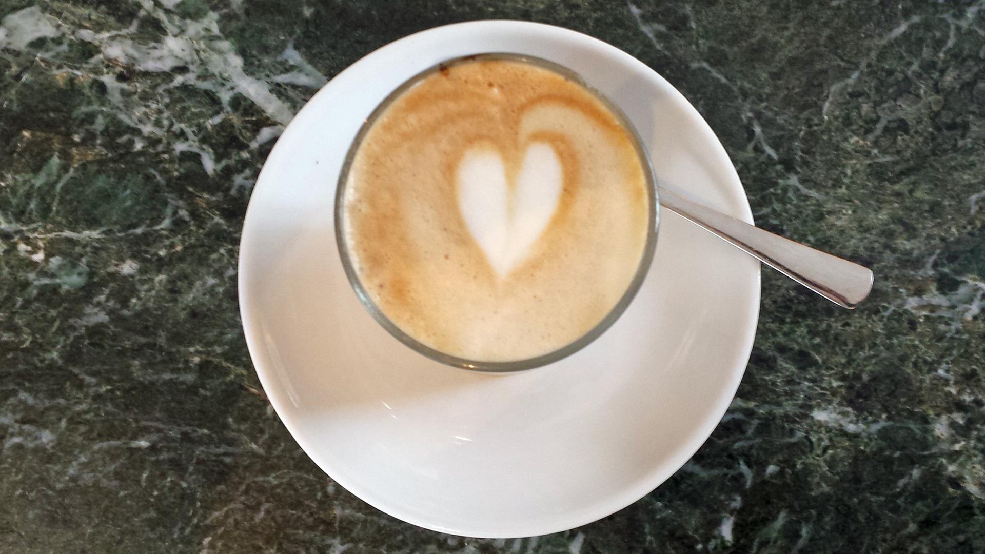 Eine Kaffeetasse mit Milchschaum in Herzform. Eine Kaffeetasse mit Milchschaum in Herzform.