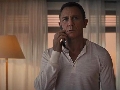 Schauspieler Daniel Craig alias James Bond telefoniert mit dem Smartphone.