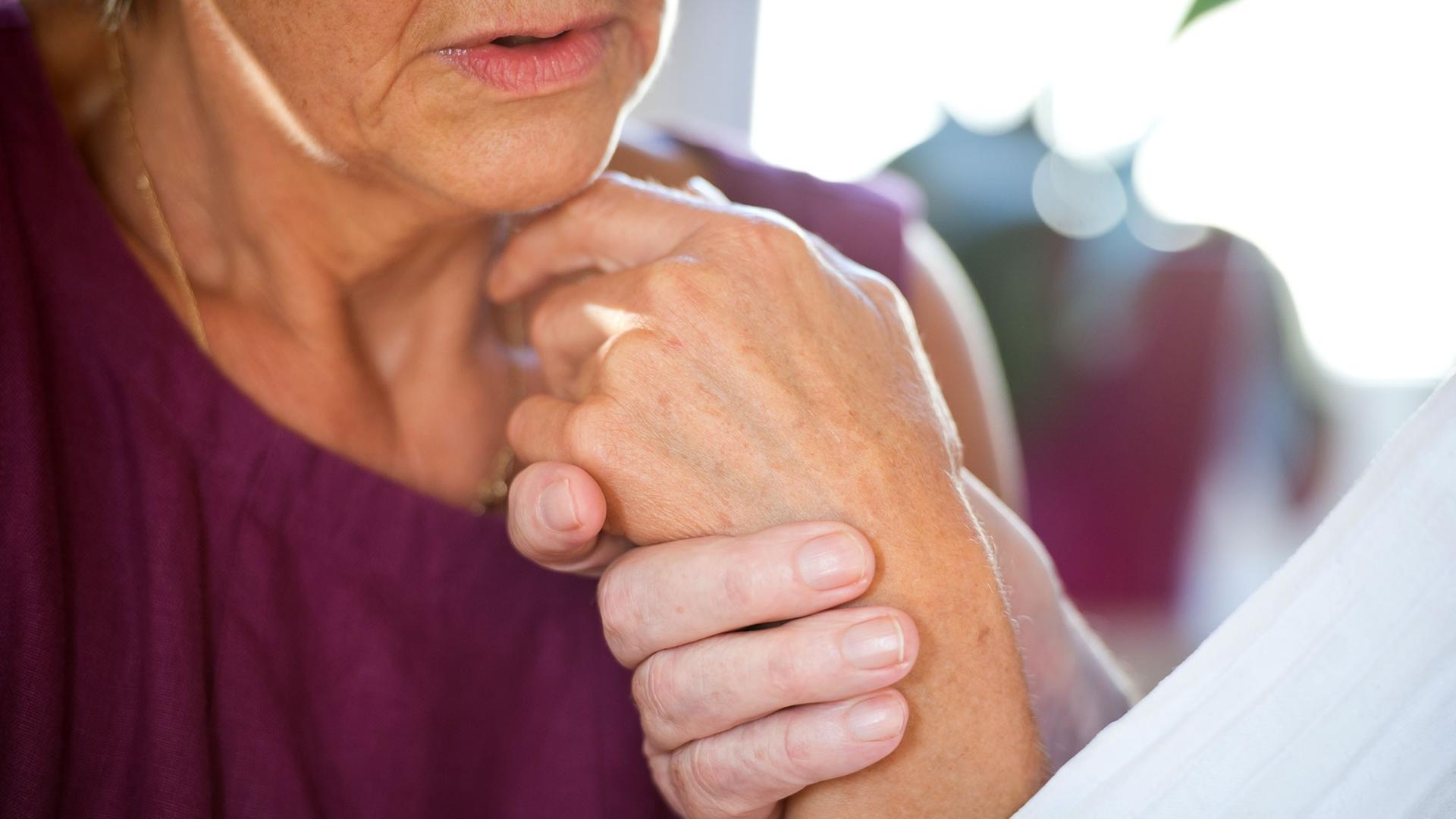 Eine Frau hält die Hand ihres an Demenz erkrankten Mannes. Eine Frau hält die Hand ihres an Demenz erkrankten Mannes.
