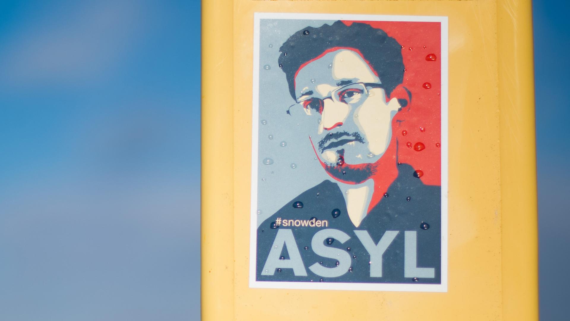 Ein Aufkleber, mit dem Asyl für den Informanten Edward Snowden gefordert wird, klebt am 11.02.2014 auf einem Masten bei Beckedorf im Landkreis Schaumburg (Niedersachsen). Ein Aufkleber, mit dem Asyl für den Informanten Edward Snowden gefordert wird, klebt am 11.02.2014 auf einem Masten bei Beckedorf im Landkreis Schaumburg (Niedersachsen).