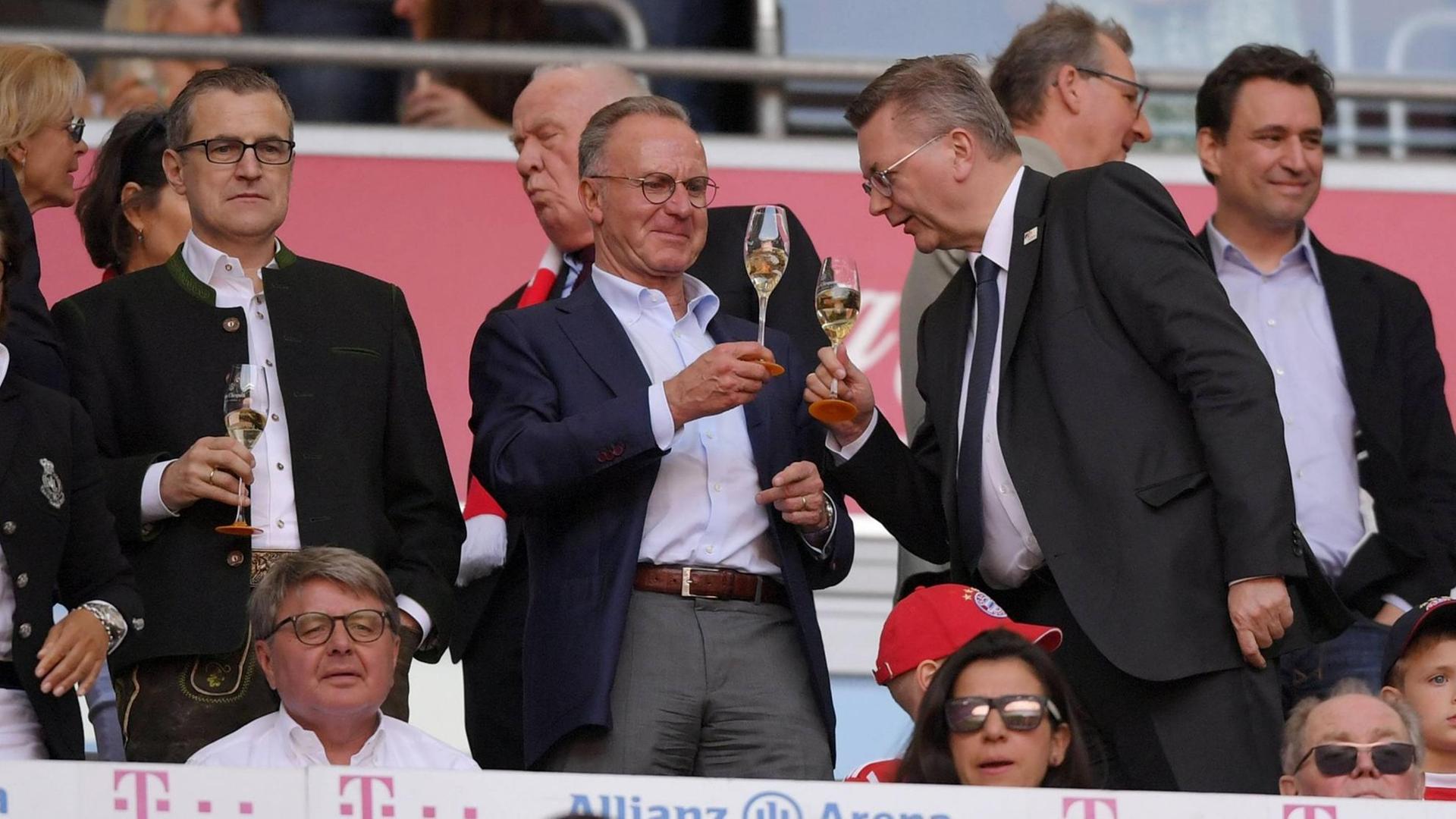 Vorstandsvorsitzender Karl-Heinz Rummenigge (FC Bayern München) und DFB-Präsident Reinhard Grindel trinken Sekt auf der Ehrentribüne.