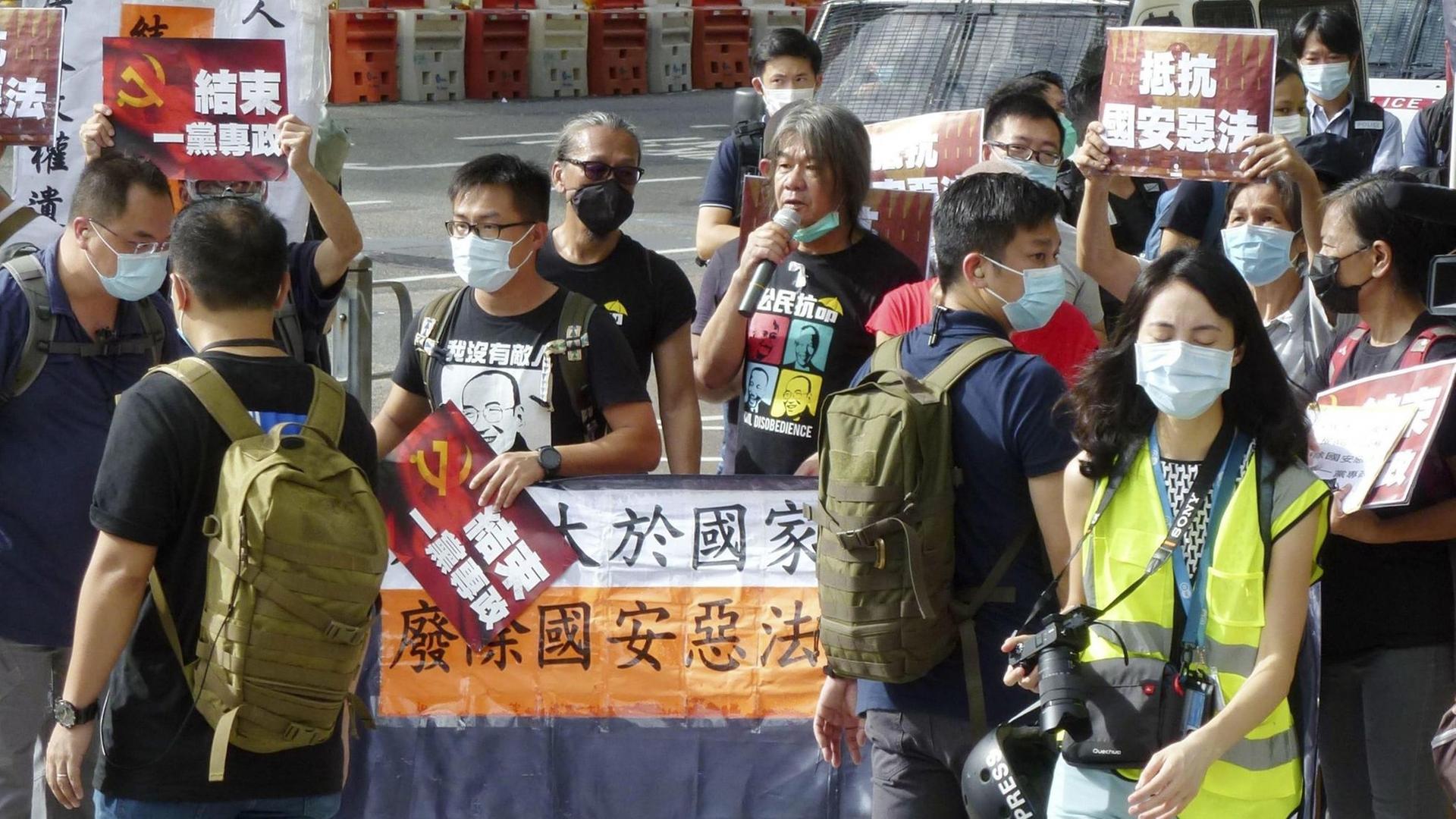 Mehrere prodemokratische Demonstranten protestieren auf den Straßen von Hongkong gegen das umstrittene Sicherheitsgesetz. Mehrere prodemokratische Demonstranten protestieren auf den Straßen von Hongkong gegen das umstrittene Sicherheitsgesetz.