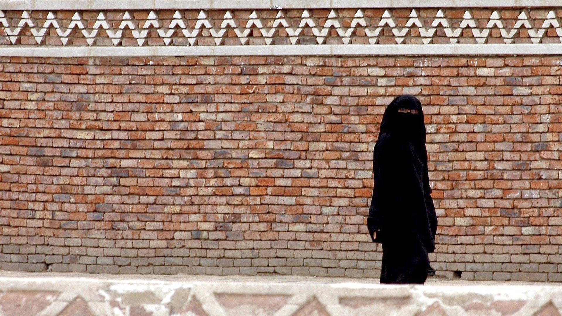 Eine jemenitische Frau in der Burka geht auf einer Straße in der Altstadt von Sanaa am 15 August 2007. Eine jemenitische Frau in der Burka geht auf einer Straße in der Altstadt von Sanaa am 15 August 2007.