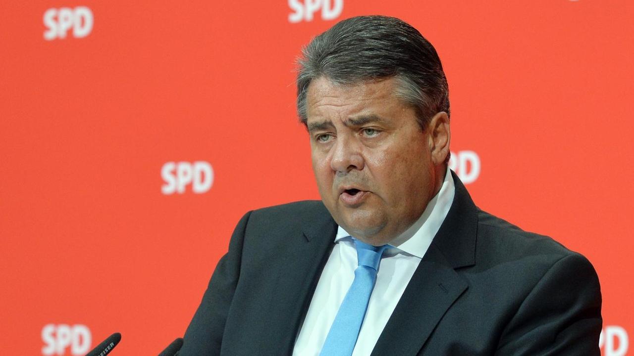 Der SPD-Vorsitzende Sigmar Gabriel spricht vor einer roten Wand mit SPD-Logos in ein Mikrofon. Der SPD-Vorsitzende Sigmar Gabriel spricht vor einer roten Wand mit SPD-Logos in ein Mikrofon.