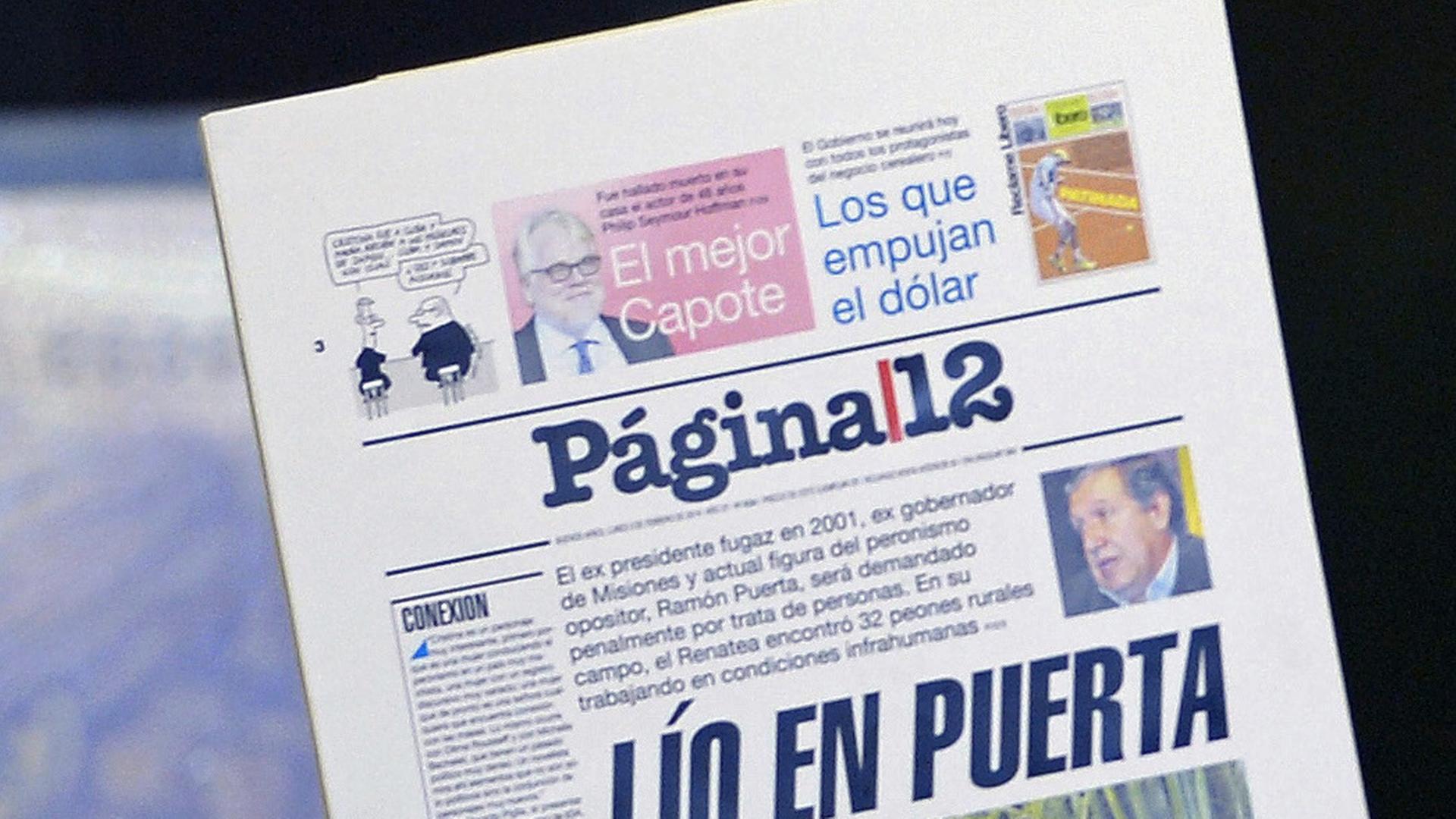 Argentine President Cristina Fernandez de Kirchner shows the front page of a newspaper as she announces rises in basic pensions at the Government Palace in Buenos Aires on February 4, 2014. Argentine President Cristina Fernandez de Kirchner shows the front page of a newspaper as she announces rises in basic pensions at the Government Palace in Buenos Aires on February 4, 2014.