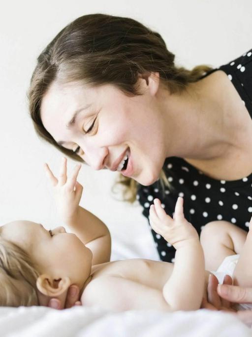 Ein Baby spielt mit seiner Mutter.