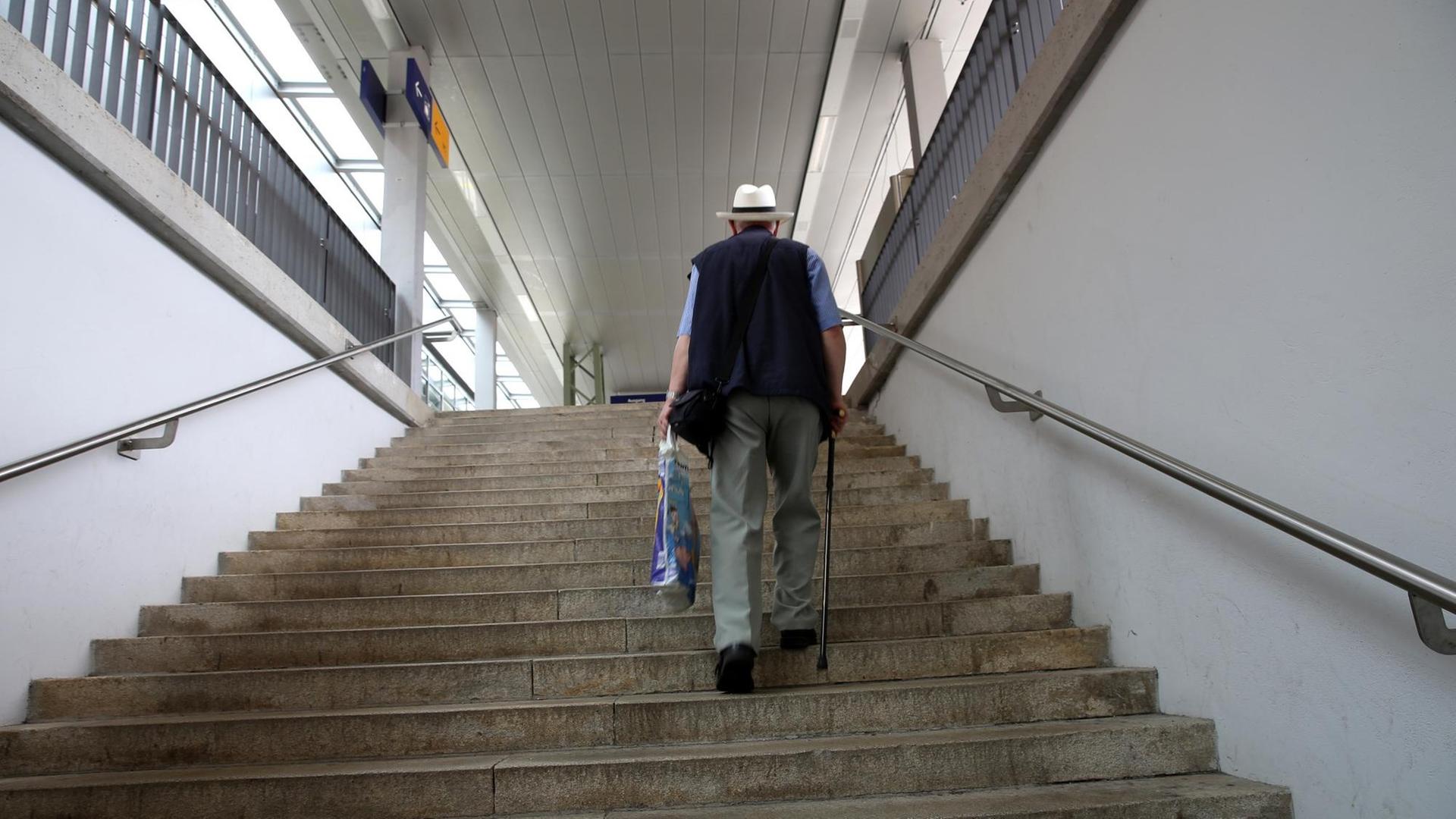 Ein älterer Herr mit Gehstock trägt eine Plastiktüte und steigt eine Treppe hoch. Ein älterer Herr mit Gehstock trägt eine Plastiktüte und steigt eine Treppe hoch.