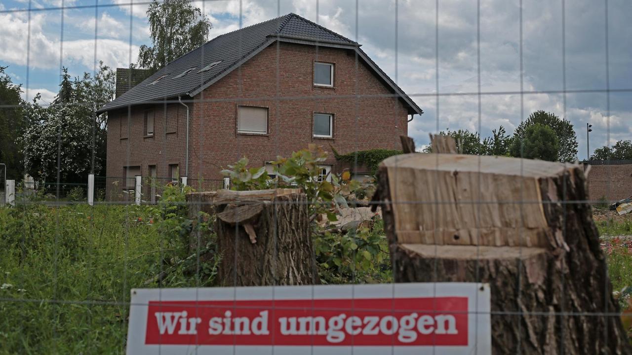 Ein Schild mit der Aufschrift "Wir sind umgezogen" steht vor einem leerstehenden Haus in Manheim.