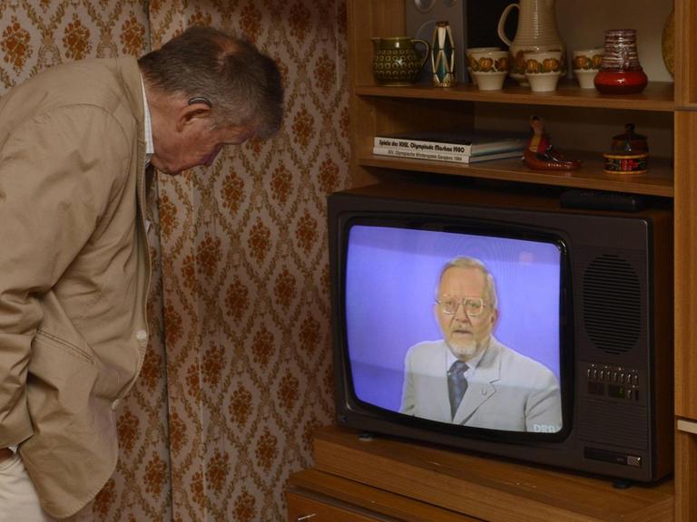 Ein Besucher des DDR-Museums blickt auf einen Fernseher in dem die Sendung "Der Schwarze Kanal" mit dessen Moderator Karl-Eduard von Schnitzler läuft.
