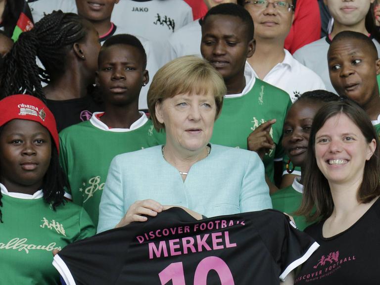 Bundeskanzlerin Angela Merkel mit Fußballerinnen des Discover Football Festivals.