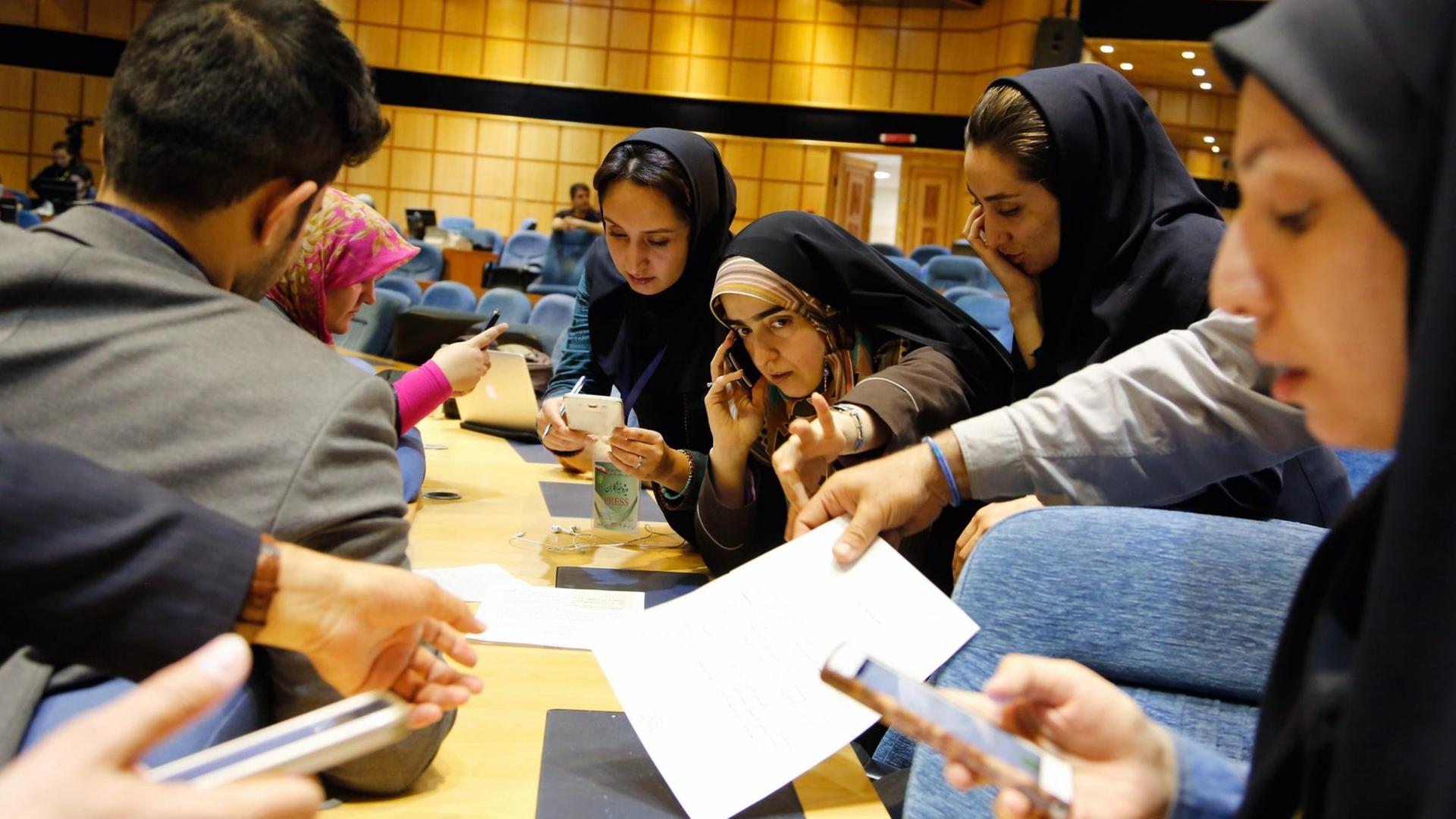 Iranische Journalisten im Innenministerium in Hauptstadt Teheran verfolgen mit ihren Smartphones erste Ergebnisse der Parlamentswahl.