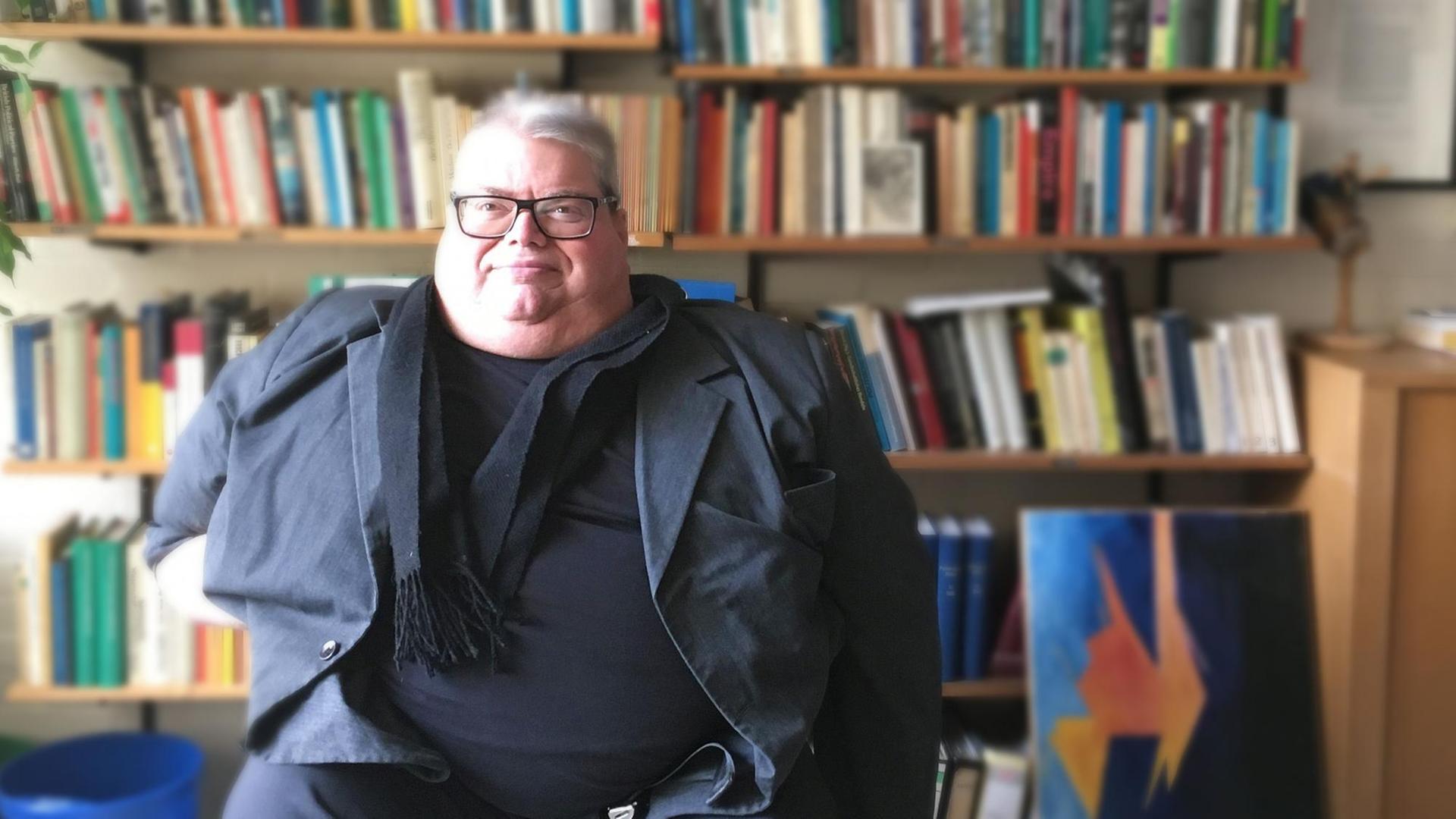 Professor für Politische Theorie und Ideengeschichte Thomas Noetzel vor einem Bücherregal. Er guckt gerade in die Kamera, von links scheint Licht durchs Fenster. Professor für Politische Theorie und Ideengeschichte Thomas Noetzel vor einem Bücherregal. Er guckt gerade in die Kamera, von links scheint Licht durchs Fenster.