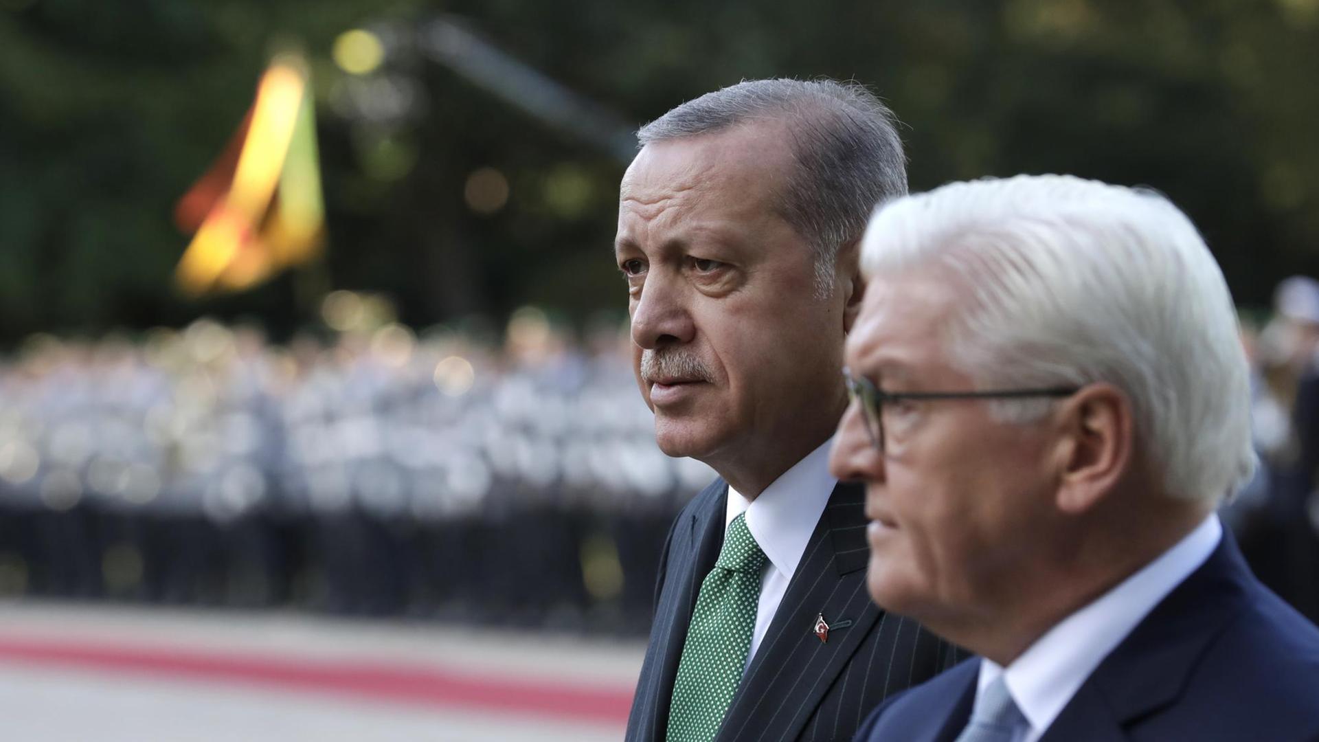 Der türkische Präsident Erdogan und Bundespräsident Steinmeier stehen nebeneinander und nehmen die Ehrenformation der Bundeswehr ab. Der türkische Präsident Erdogan und Bundespräsident Steinmeier stehen nebeneinander und nehmen die Ehrenformation der Bundeswehr ab.