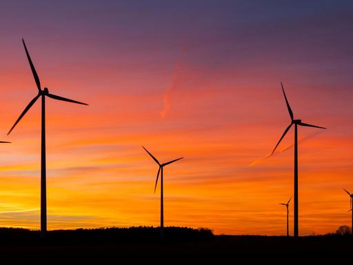 DEU/Deutschland/Brandenburg/Wormlage, 07.01.2014: Windenergie in Brandenburg; Windraeder stehen auf einem Feld bei Wormlage in der brandenburgischen Lausitz vor dem vom Sonnenuntergang rot gefaerbten Abendhimmel. // Wind engines on a field near Wormlage in Brandenburg. // **Foto: Andreas Franke** | Verwendung weltweit