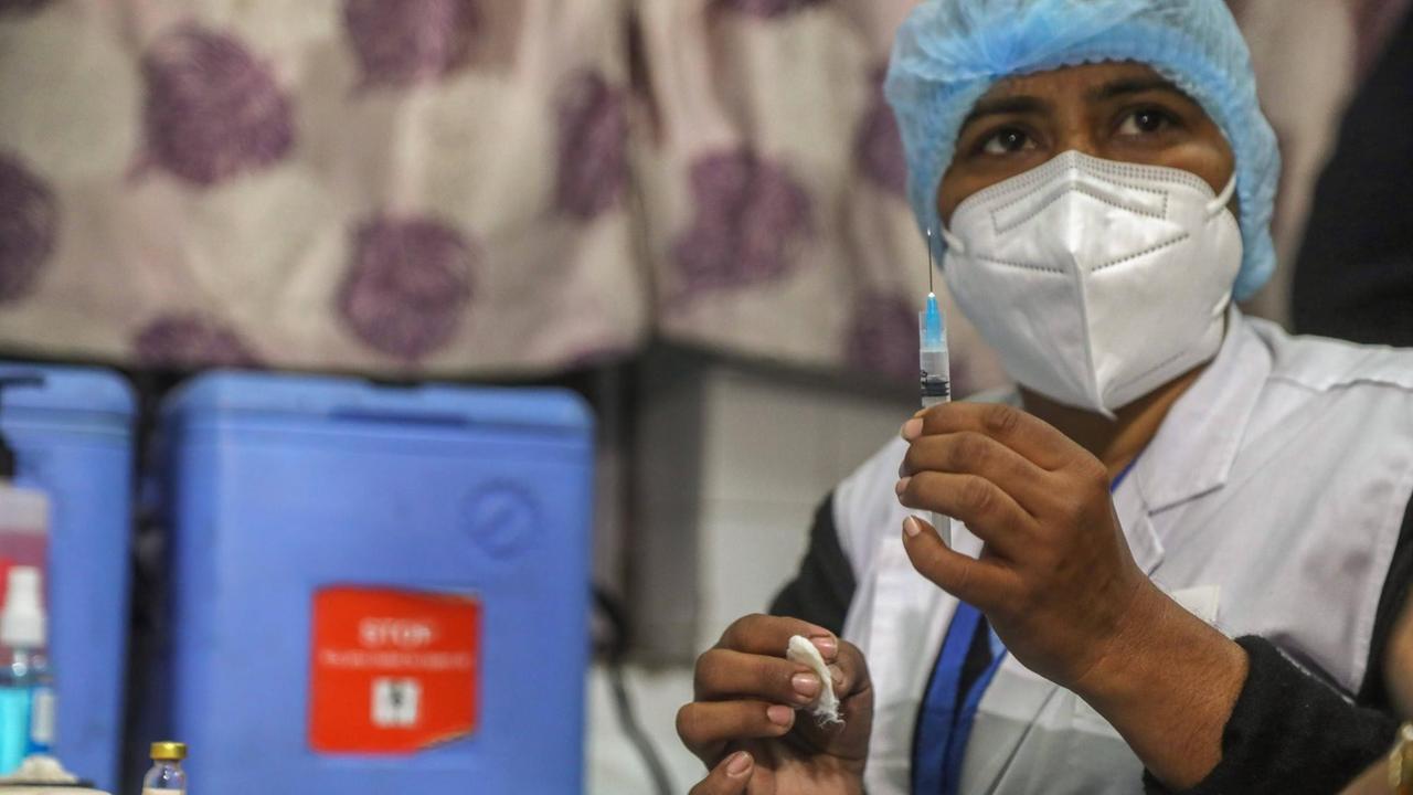 Eine Ärztin hält einen Corona-Impfstoff bereit.
