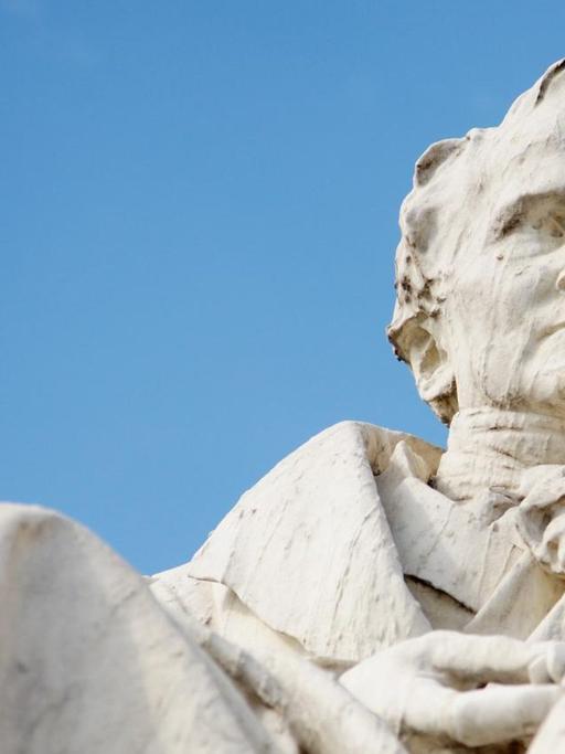 Das Denkmal für Alexander von Humboldt vor der Humboldt-Universität in Berlin vor blauem Himmel