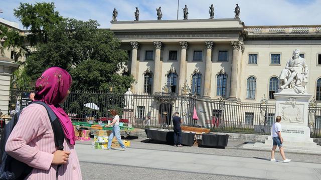29.06.2018, Berlin: Eine Frau mit Kopftuch geht an der Humboldt-Universität an der Straße Unter den Linden in Berlin vorbei.