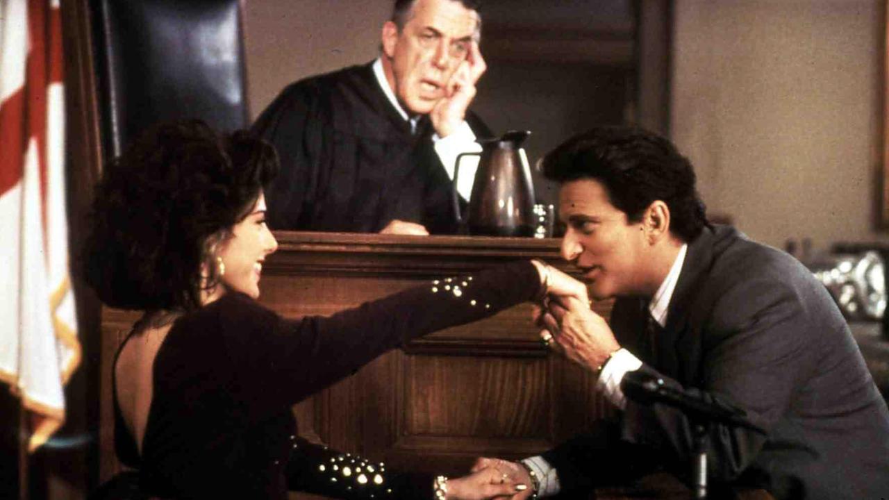 Szene aus "Mein Cousin Winnie" im Gericht: Joe Pesci küsst Marisa Tomei die Hand, während sie im Zeugenstand ist, im Hintergrund Fred Gwynne auf dem Richterstuhl. Szene aus "Mein Cousin Winnie" im Gericht: Joe Pesci küsst Marisa Tomei die Hand, während sie im Zeugenstand ist, im Hintergrund Fred Gwynne auf dem Richterstuhl.