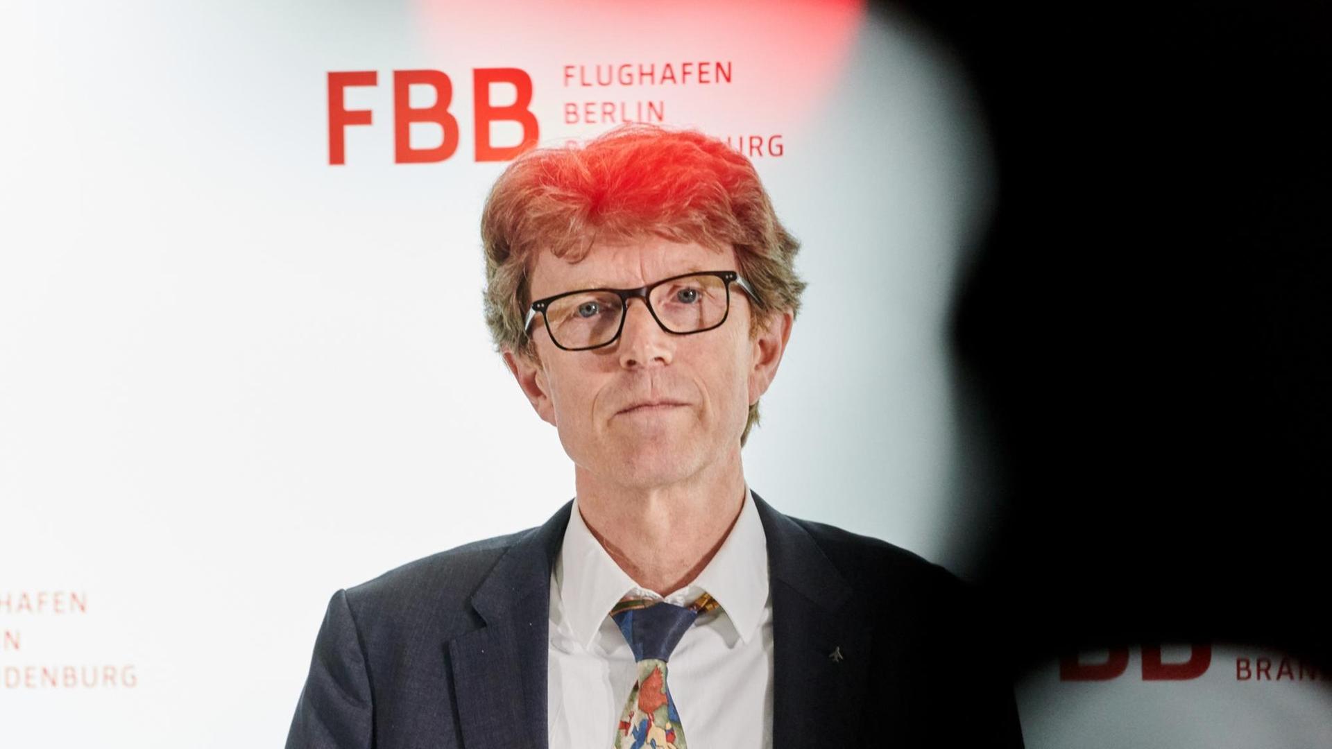 Engelbert Lütke Daldrup steht vor einer Wand auf der FBB steht und schaut in die Kamera. Engelbert Lütke Daldrup steht vor einer Wand auf der FBB steht und schaut in die Kamera.