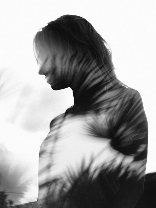 Schwarzweißfotografie der Silhouette einer Frau mit iritierenden Lichtspielereien