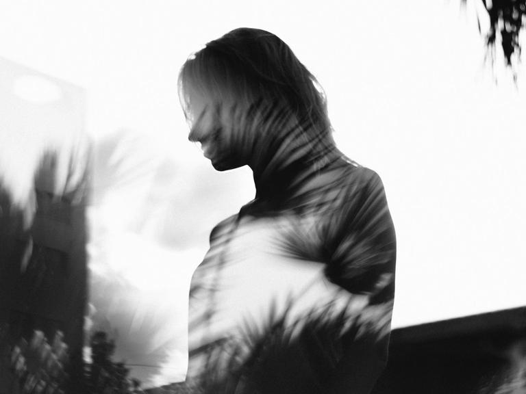 Schwarzweißfotografie der Silhouette einer Frau mit iritierenden Lichtspielereien