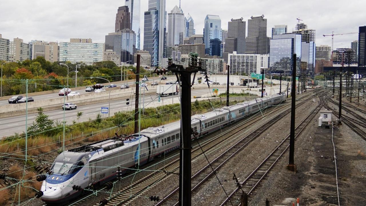 An Amtrak train departs 30th Street Station moving parallel to motor vehicle traffic on Interstate 76 in Philadelphia, Wednesday, Oct. 27, 2021. (AP Photo/Matt Rourke)