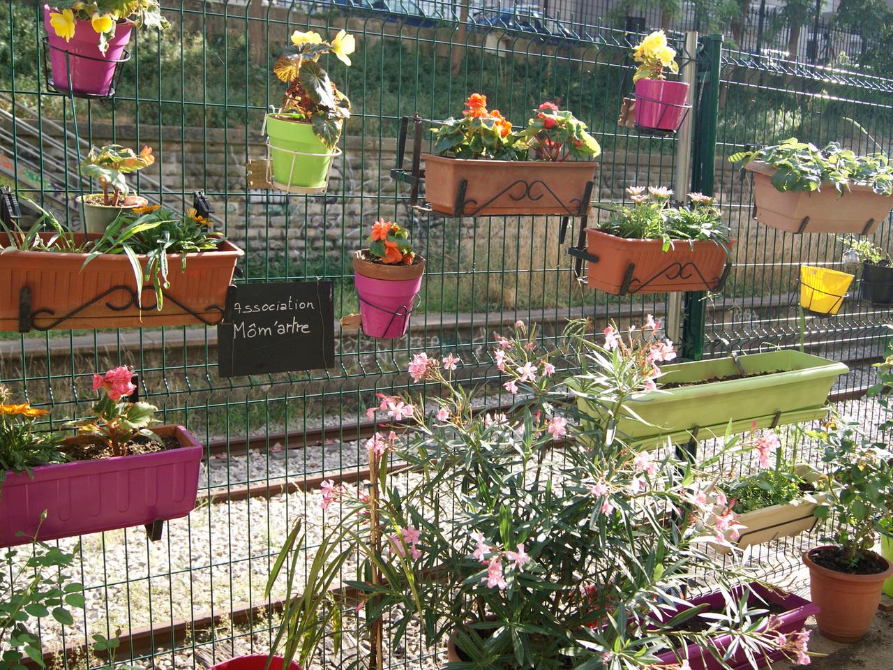 Blumenkästen am Zaun eines Gemeinschaftsgartens in Paris. In der Metropole verschaffen sich Städter mit gemeinschaftlichen Gärten einen natürlichen Lichtblick.