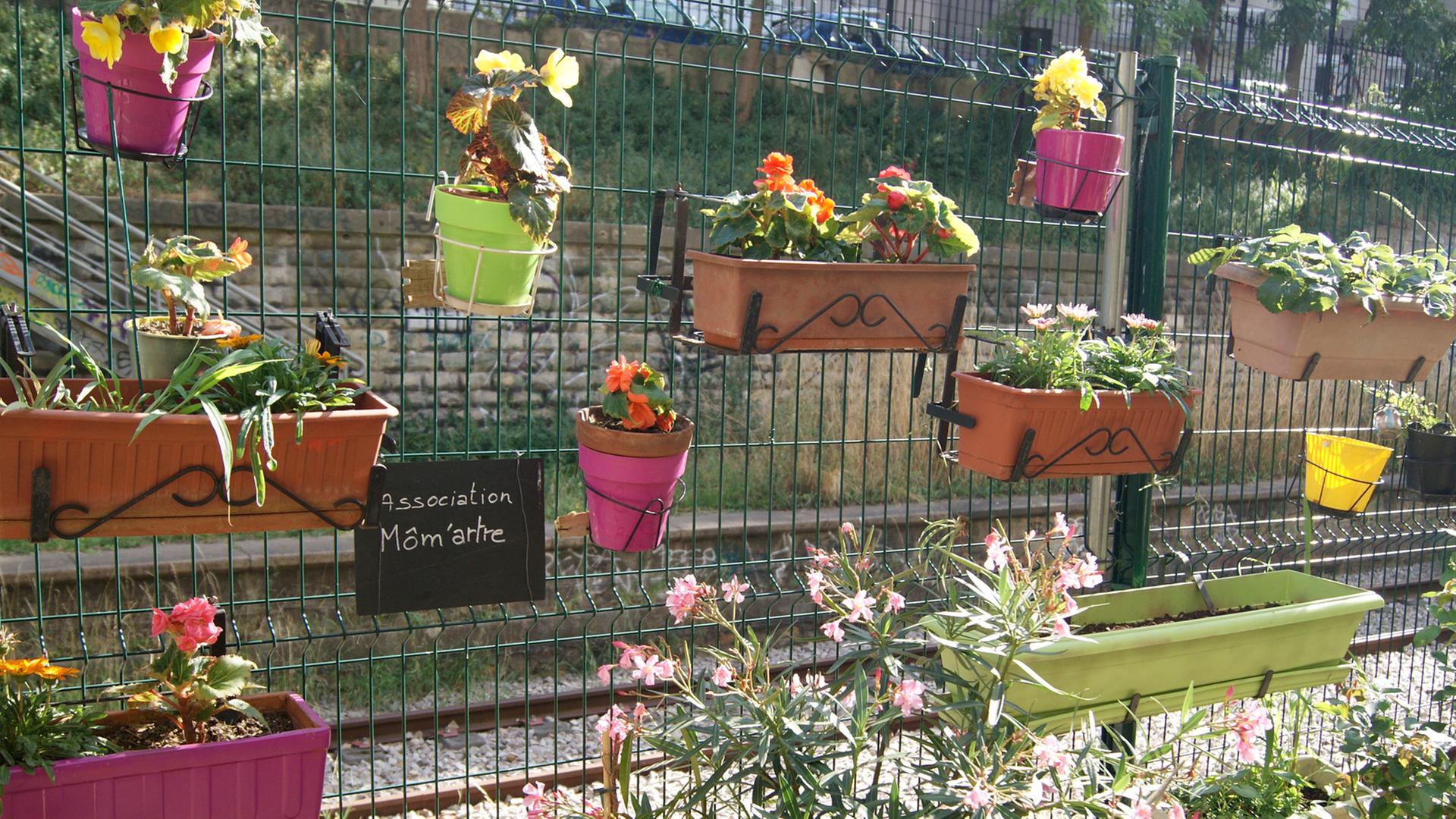 Blumenkästen hängen an einem Metallzaun in Paris Blumenkästen hängen an einem Metallzaun in Paris