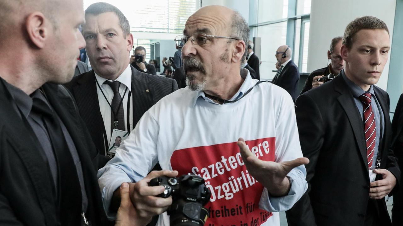 Das Foto zeigt den türkischen Journalisten und Regierungskritiker Adil Yigit auf einer Pressekonferenz im Bundeskanzleramt. Er wird von Ordnern aus dem Saal gebracht.