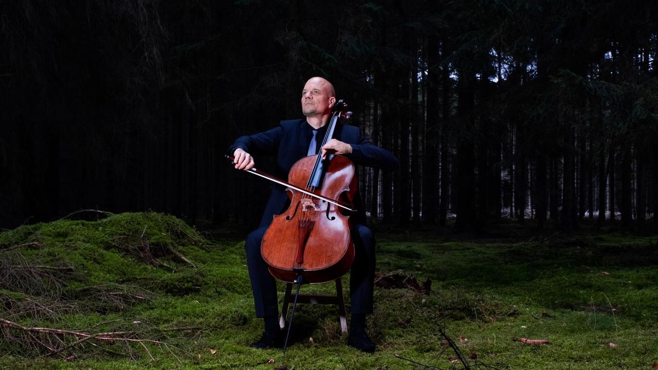 Eckart Runge spielt Cello auf einer kleinen Waldlichtung. Eckart Runge spielt Cello auf einer kleinen Waldlichtung.