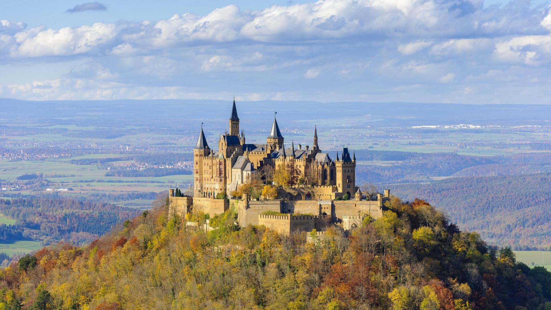 Das Bild zeigt die Burg Hohenzollern auf der schwäbischen Alb im Herbst vor einem Himmel mit vielen Wolken. Das Bild zeigt die Burg Hohenzollern auf der schwäbischen Alb im Herbst vor einem Himmel mit vielen Wolken.