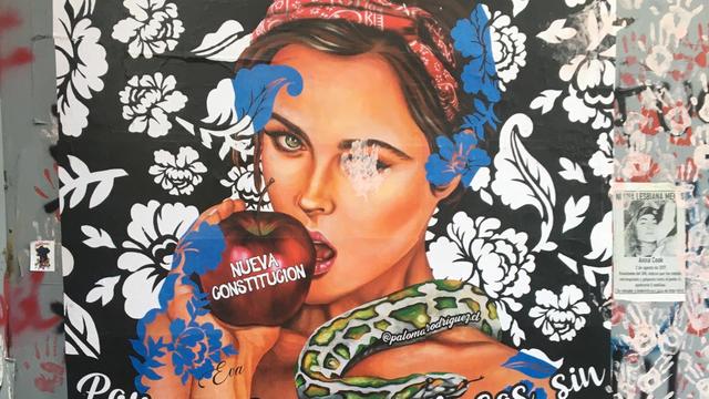 Ein Wandbild: Das Portrait einer jungen Frau, die in einen Apfel beißt, eine Schlange liegt über ihrer Schulter, im Hintergrund florale Muster