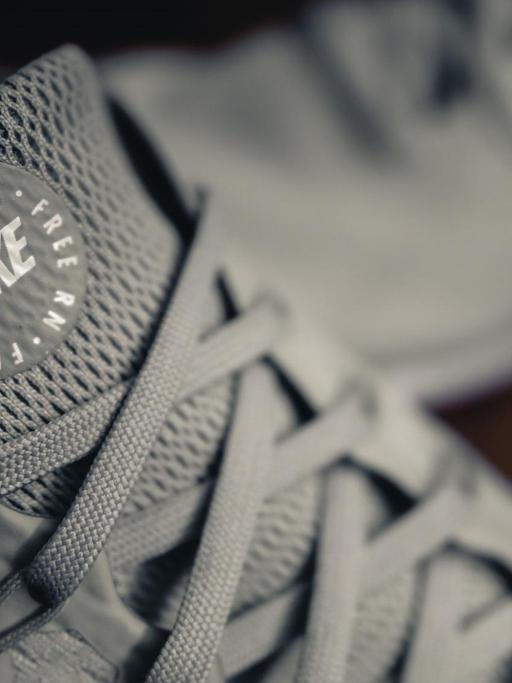 Nahaufnahme der Lasche von grauen Nike-Turnschuhen mit der Aufschrift "Free RN".