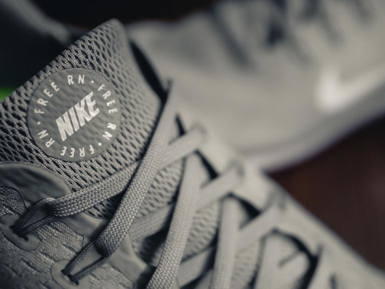 Nahaufnahme der Lasche von grauen Nike-Turnschuhen mit der Aufschrift "Free RN".