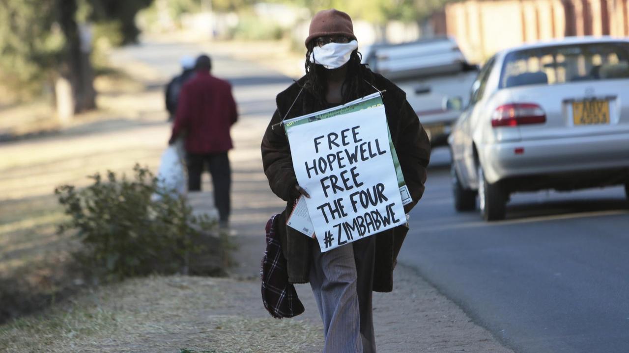 Tsitsi Dangarembga auf der Straße mit einem Schild vor dem Körper "Free Hopewell - Free The Four - #Zimbabwe