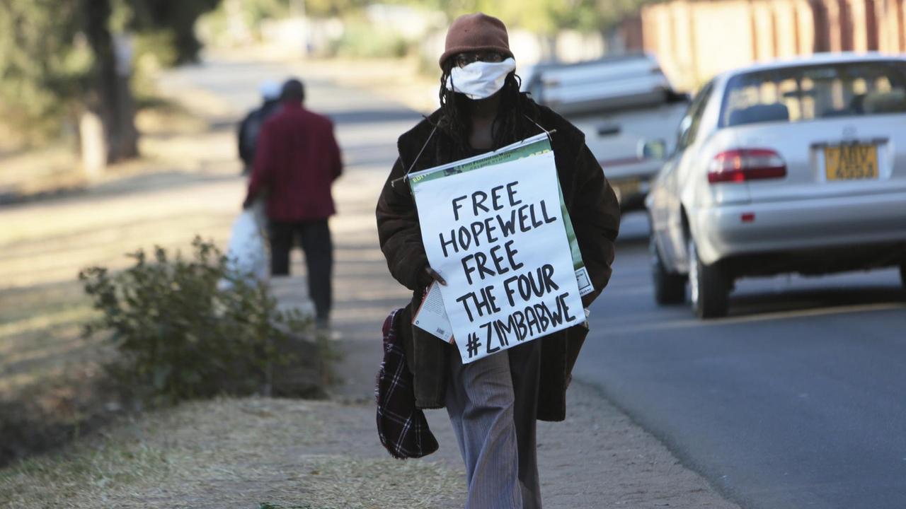 Tsitsi Dangarembga auf der Straße mit einem Schild vor dem Körper "Free Hopewell - Free The Four - #Zimbabwe Tsitsi Dangarembga auf der Straße mit einem Schild vor dem Körper "Free Hopewell - Free The Four - #Zimbabwe