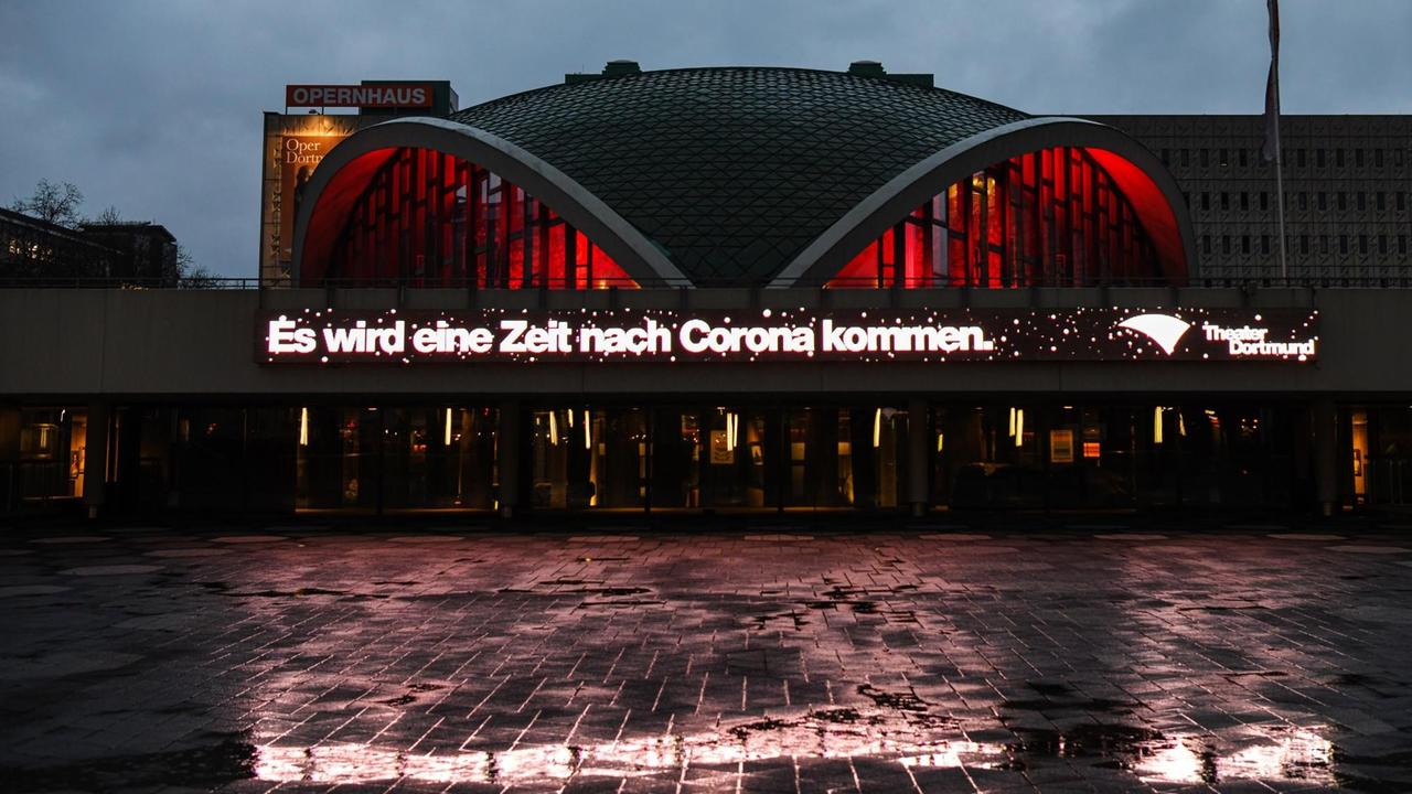 Über die ganze Breite des Gebäudes steht in roter Leuchtschrift: "Es wird eine Zeit nach Corona kommen." Über die ganze Breite des Gebäudes steht in roter Leuchtschrift: "Es wird eine Zeit nach Corona kommen."