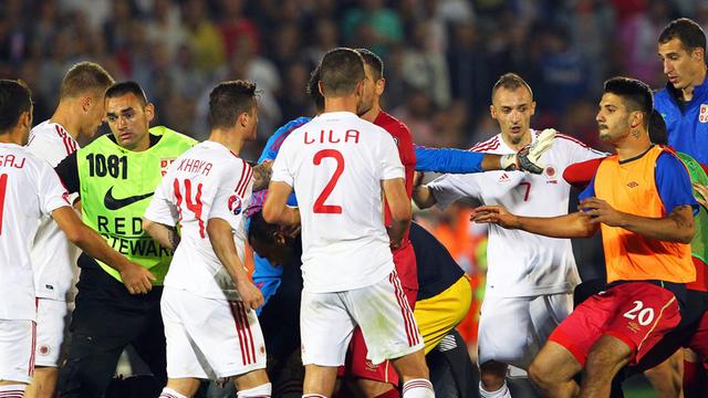 Im Belgrader Stadion liefern sich Spieler Serbiens und Albaniens eine Schlägerei. Ordner versuchen, sie auseinanderzuhalten.