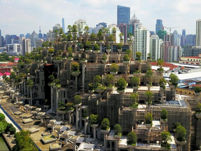 Klimafreundliches Wohngebäude in Shanghai. Auf Pfeilern und Balkonen sind massenhaft Bäume gepflanzt um die Stadtluft zu verbessern.