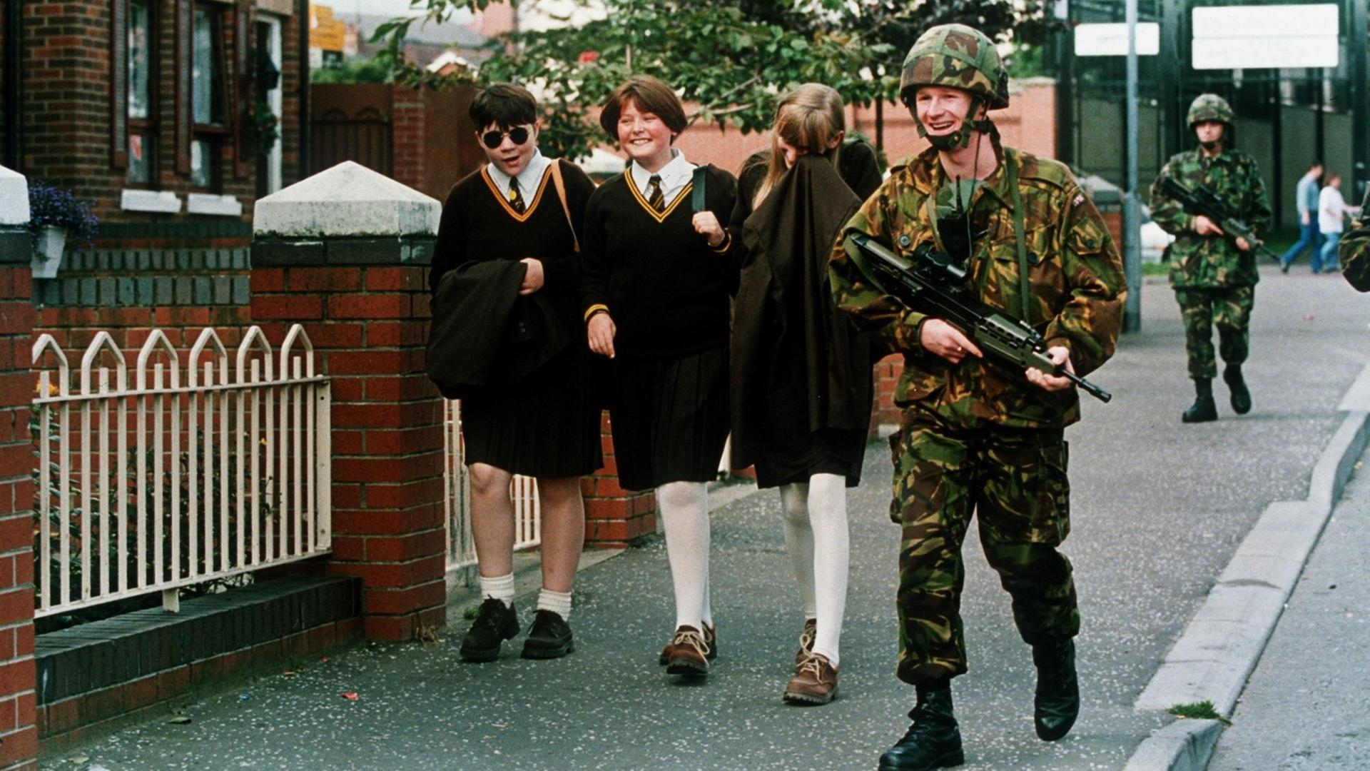 Katholische Schulmädchen lachen mit einem britischen Soldaten, der im Gebiet der Falls Road patroulliert. Nach 25 Jahren blutigem Terror hat die irische Untergundorganisation IRA am 31.08.1994 einen uneingeschränkten Gewaltverzicht erklärt und damit einen Schritt zur Beendigung des Nordirland-Konflikts getan |