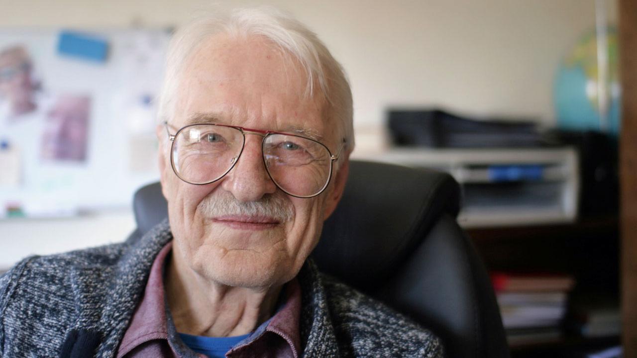 Porträtaufnahme Hans Schwingers: ein älterer Herr mit grauen Haaren und Brille. Porträtaufnahme Hans Schwingers: ein älterer Herr mit grauen Haaren und Brille.