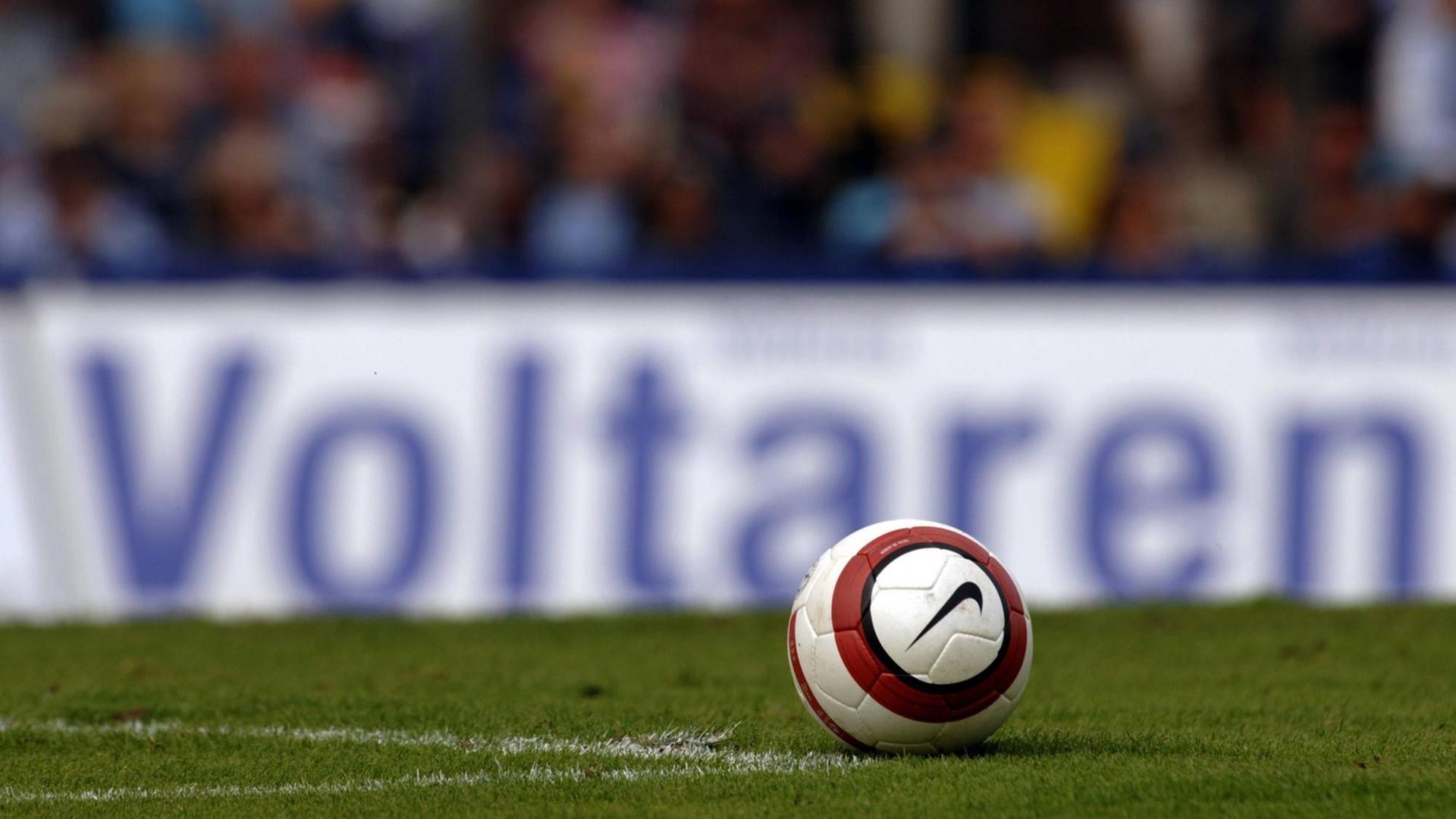 Ein Fußball liegt vor einer Werbebande des Schmerzmittel-Herstellers Voltaren Ein Fußball liegt vor einer Werbebande des Schmerzmittel-Herstellers Voltaren